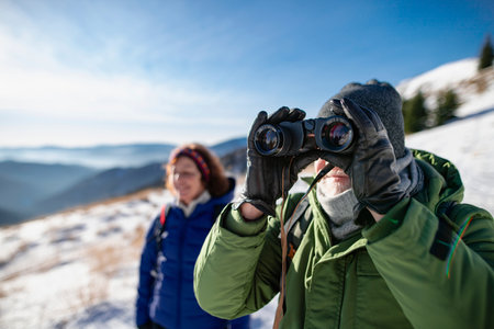 Romantic winter hike for an elderly couple in snowy mountains. Active seniors enjoying nature.の写真素材