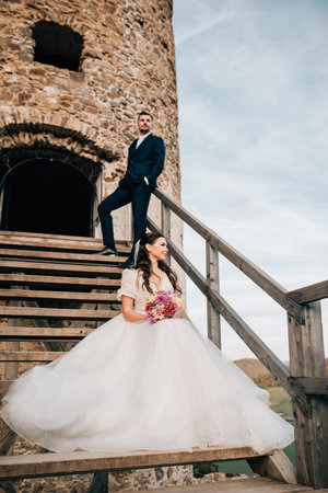Portrait of beautiful wedding couple standing outside near ruins.の写真素材