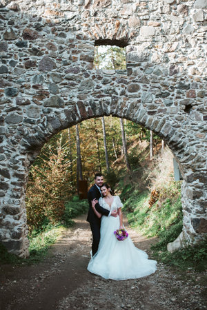 Portrait of beautiful wedding couple standing outside near ruins.の写真素材