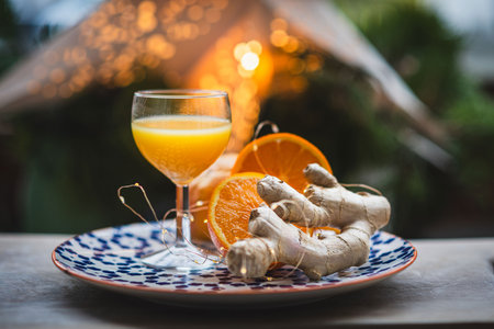 Ginger shot with fresh oranges and ginger root on rustic tableの写真素材