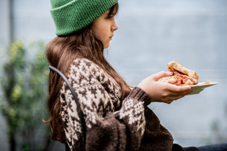 Girl enjoying a homemade baked sandwich with bacon.の写真素材