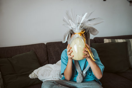 Boy with large Easter egg in front his face.