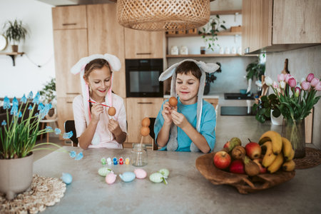 Girl and boy paiting eggs for easter.
