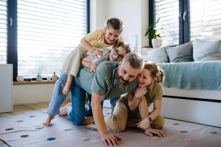 Portrait of father with three daughters at home.の写真素材