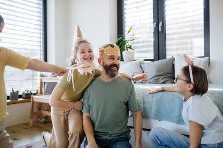 Portrait of father with three daughters at home.の写真素材