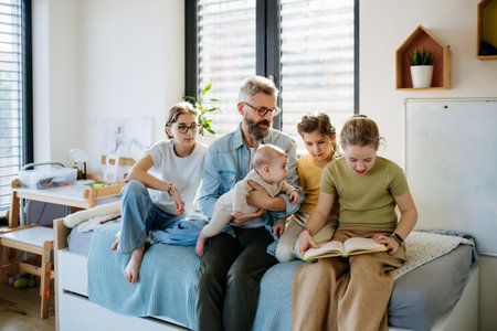 Three sisters and father taking care of newborn brother.の写真素材