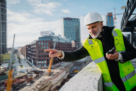 Site manager giving instructions over radio during building inspection.