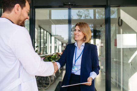 Confident female medical sales representative introducing herself to doctor.の写真素材