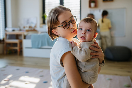 Big sister holding small little brother in her arms, taking care.の写真素材