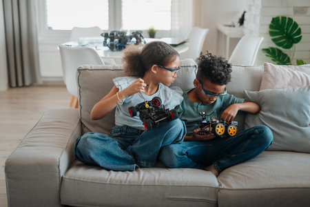 Siblings building robotic car at home as part of STEM learning.の写真素材