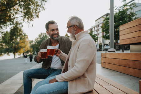 Father and son enjoying beer together outdoorsの写真素材