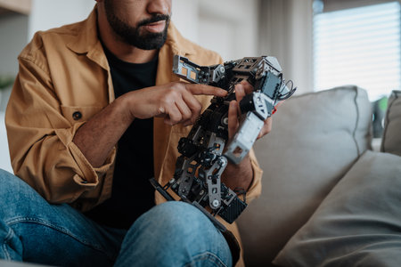 Handsome engineer student working on robot project at home.
