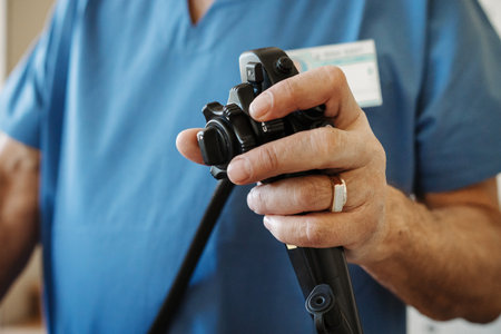 Close-up of doctor holding endoscope control in gastroenterology clinic.