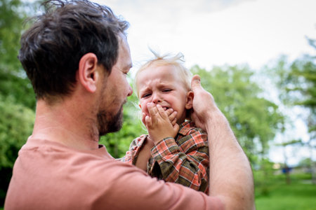 Loving father helping to injured crying toddler boy.の写真素材