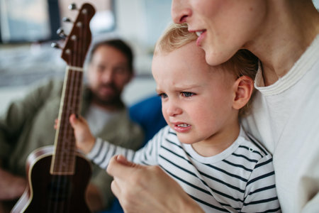 Little boy holding guitar, learning to play.の写真素材