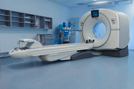 Modern CT scanner in empty radiology exam room.