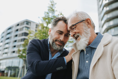 Father and adult son sharing a joyful moment outdoorsの写真素材