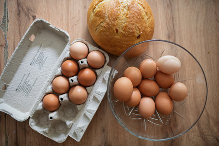 Fresh brown eggs in carton and glass bowlの写真素材