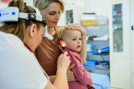 Otolaryngologist examining toddler in pediatric clinicの写真素材