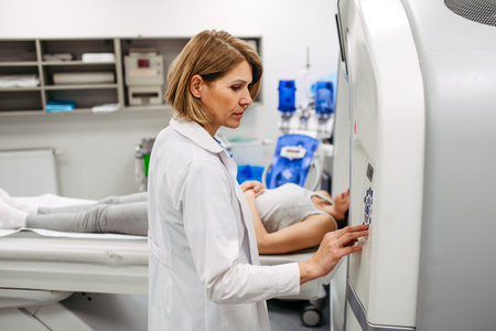 Doctor operating CT machine and preparing patient for scanの写真素材