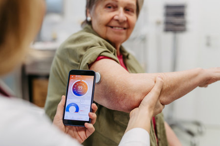 Endocrinologist teaching older patient how to connect continuous glucose monitor with mobil app.