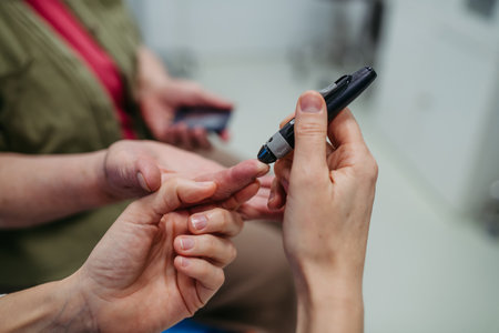 Female doctor teaching older patient how to check her blood sugar level.の写真素材