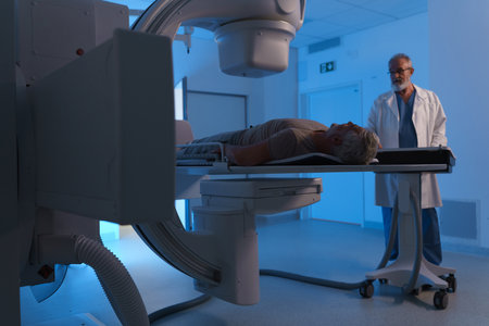 Male patient undergoing X-ray examination using tilting radiographic wall stand.の写真素材