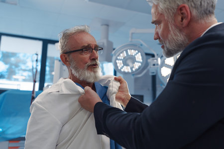 Aggressive man have conflict with doctor, holding him by coat.の写真素材