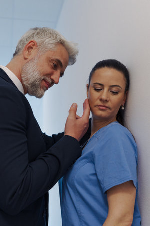 Hospital manager harassing attractive nurse in healthcare setting.の写真素材