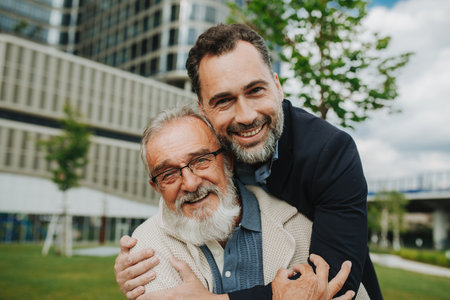 Portrait of handsome mature man and his older father hugging each other.の写真素材