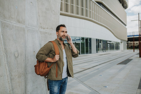 Portrait of middle-aged man making phone call outdoors.の写真素材