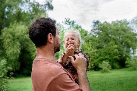 Loving father helping to injured crying toddler boy.の写真素材