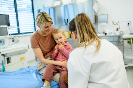 Pediatrician talking little boy during preventive health check up.