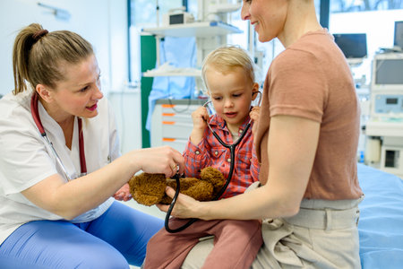 Little boy trying pediatricians stethoscope during medical examination.の写真素材