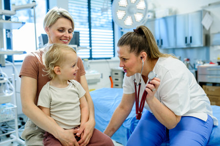 Doctor listening little boys heartbeat and breathing during preventive medical checkup.の写真素材