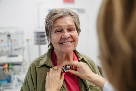 Geriatrician doctor examining elderly patient with stethoscope.の写真素材