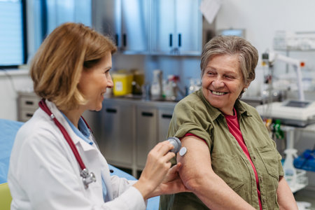 Female doctor applying CGM sensor to senior patients armの写真素材