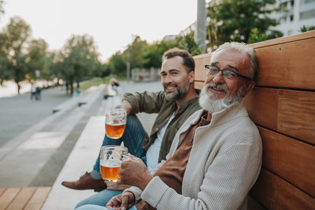 Happy father and son sharing drinks on a sunny dayの写真素材