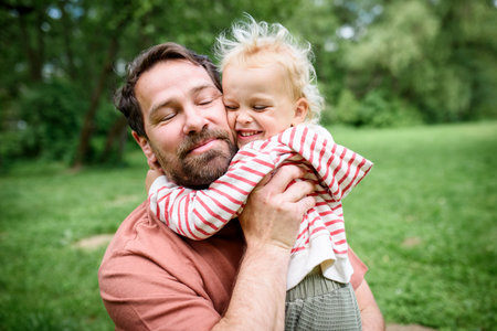 Portrait of dad hugging little son, enjoying time togetherの写真素材