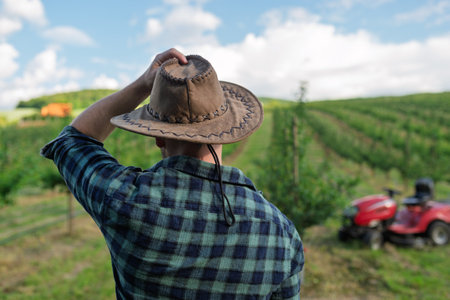 A mature farmer looking at his orchard at sunset. Copy space.の写真素材
