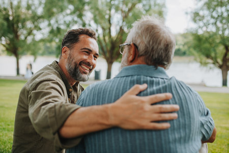 Happy dad and adult son enjoying peaceful afternoon outdoorsの写真素材