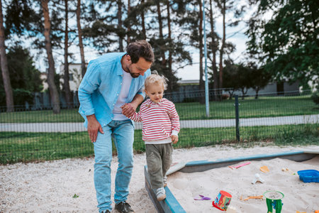Portrait of dad and child enjoying time together on the playground.の写真素材