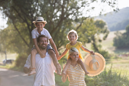 A portrait of young family with small children in sunny summer nature.