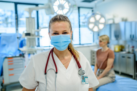 Doctor in face mask standing in examination room.の写真素材