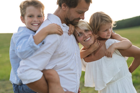 Young family enjoying peaceful summer evening outdoors in green summer natureの写真素材