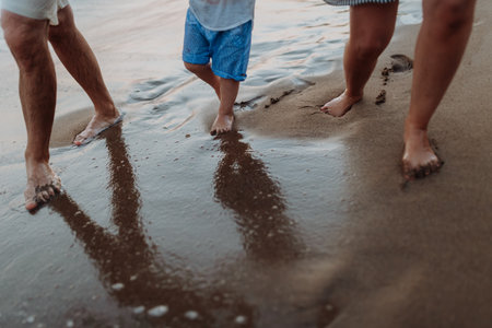 Legs and feet of family standing on beach on summer holiday, a midsection.の写真素材