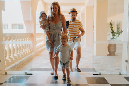 Family entering hotel on summer vacation with childrenの写真素材