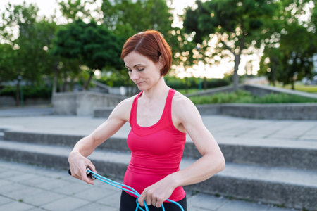 Young woman doing exercise outdoors in city with skipping rope.の写真素材