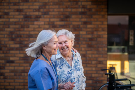 Home caregiver with elderly patient outside.