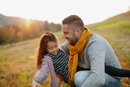 Father and young girl on walk in autumn nature, spending sunday outdoors.